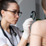Une femme examine sa peau avec une loupe, concentrée sur les détails de son épiderme.